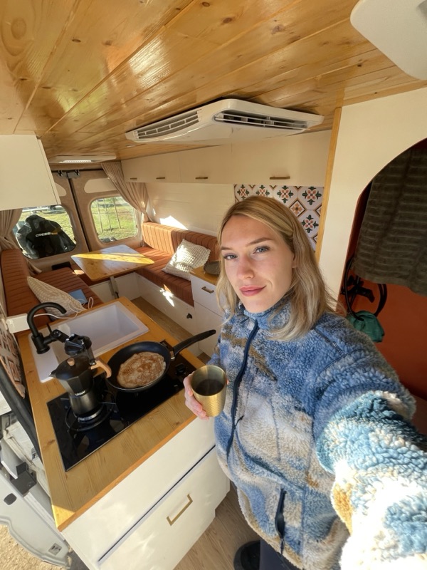 Saskia with a morning coffee in the van kitchen